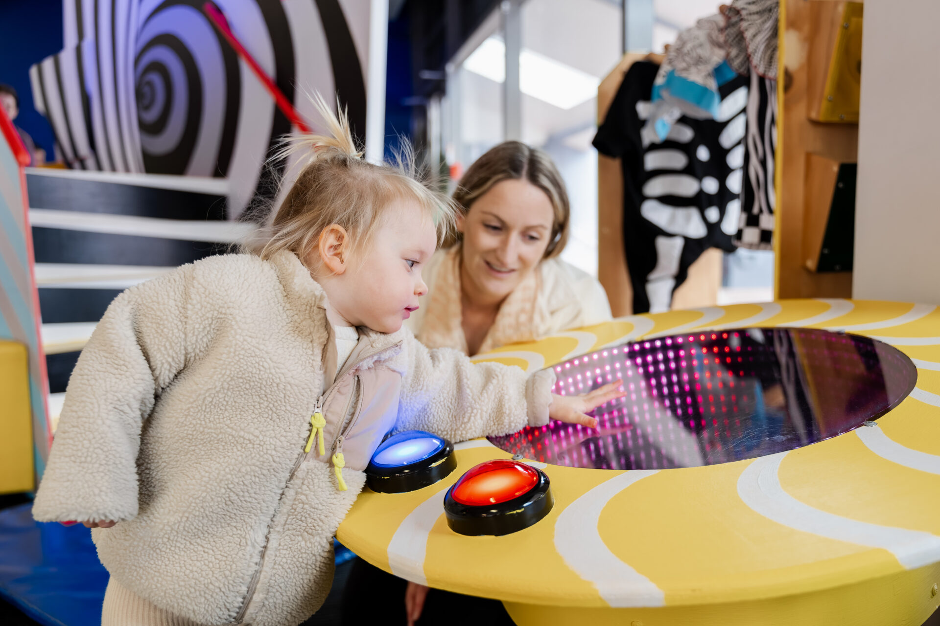 A girl and her caregiver playing in PlayHQ.