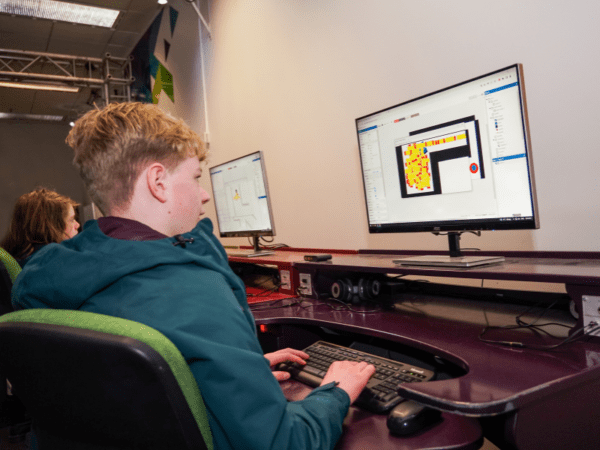 Child using a computer to create a two-dimensional game in the MediaLab.