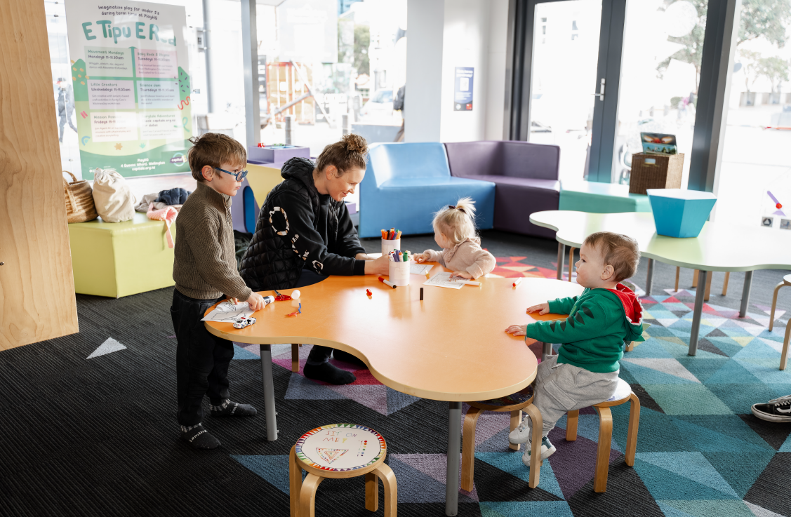 People sitting at the craft table in PlayHQ