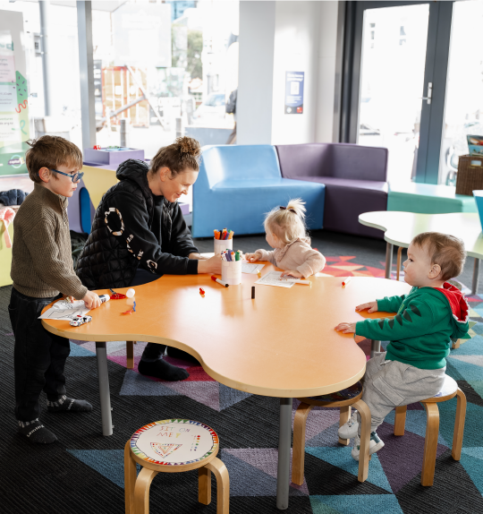 People sitting at the craft table in PlayHQ