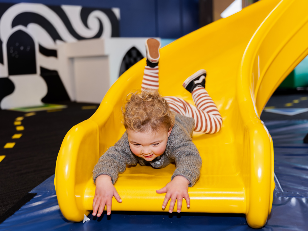 A child on a slide in PlayHQ